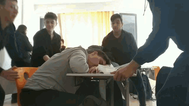 a boy laying on the floor with his head on a book