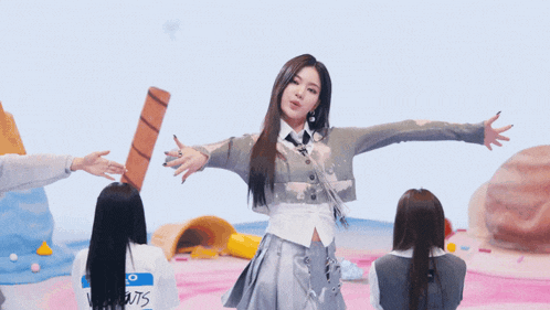 a group of young women are dancing together and one of them is wearing a gray sweater