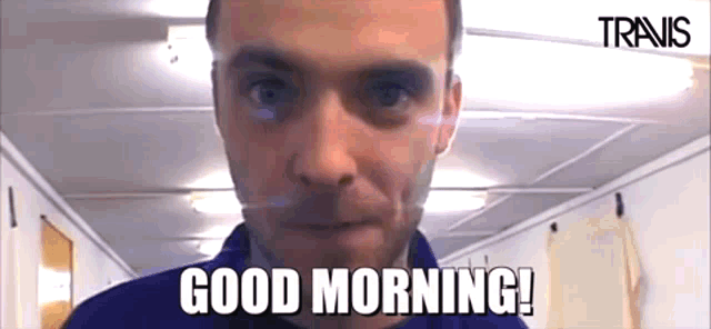 a man says good morning in front of a travis logo