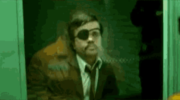 a man in a suit and tie with an eye patch on his eye