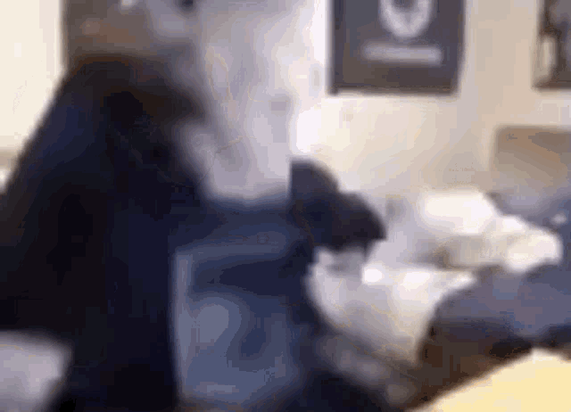a blurry picture of a person standing next to a bed in a bedroom .