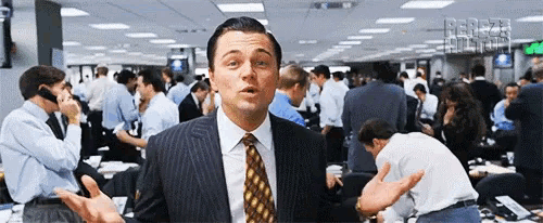 a man in a suit and tie stands in a crowded office