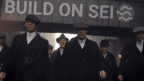 a group of men are walking in front of a building that says build on sei