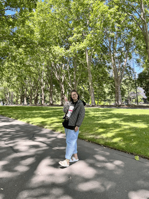 a woman wearing a t-shirt that says ' i love you ' is walking in a park