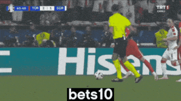 a soccer game is being played in front of a hisense sign