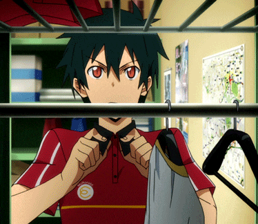 a boy in a red shirt with the letter o on it is standing in a closet