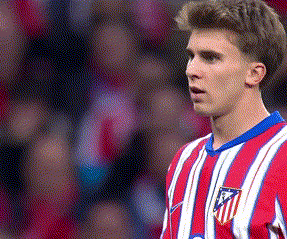 a soccer player wearing a red and white striped jersey with a badge on the chest