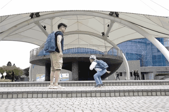 a man with a backpack is standing next to a boy with a helmet