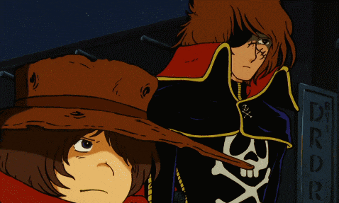 a man with a skull and crossbones on his jacket stands next to another man