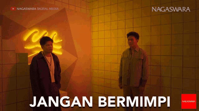 two men standing in front of a wall with the words jangan bermimpi