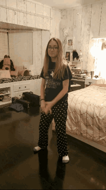 a girl standing in a bedroom wearing a shirt that says ' texas ' on it