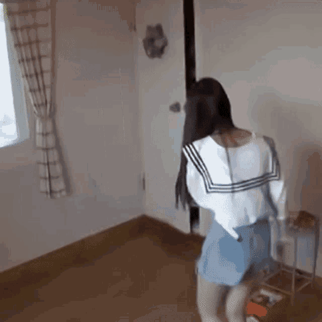 a woman is standing in a room with a door open and a window .