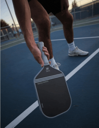 a man is holding a paddle that says ' slazenger ' on the side