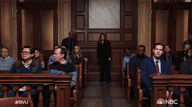 a group of people sitting in a courtroom with a nbc logo in the corner