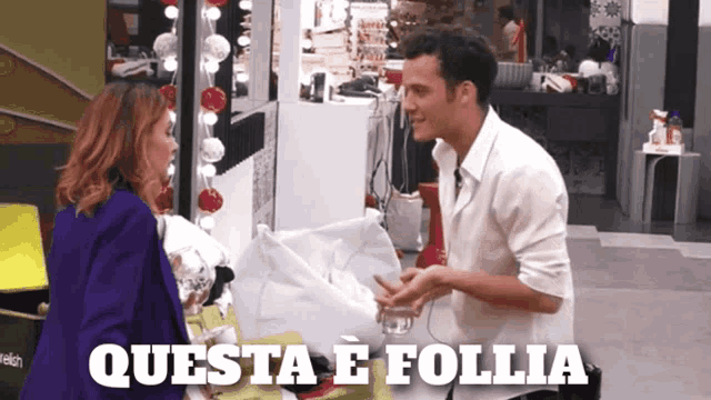 a man and a woman are standing next to each other and the words questa e follia are on the bottom