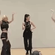 a group of women are dancing in a room while a man watches .