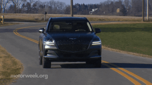 a black car is driving down a road with motorweek.org written in the corner