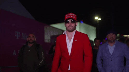 a man wearing a red suit and a maga hat