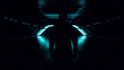 a man in a petronas shirt stands in front of a tunnel of lights