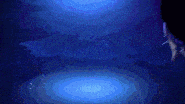 a person is swimming in the ocean with a light shining on them