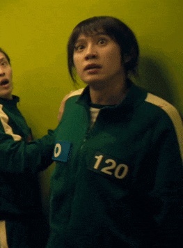 a woman in a green jacket with the number 120 on her chest