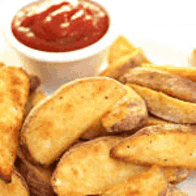 a close up of a plate of potato wedges with ketchup on a table .