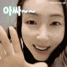 a close up of a woman 's face with a hand waving in front of her .