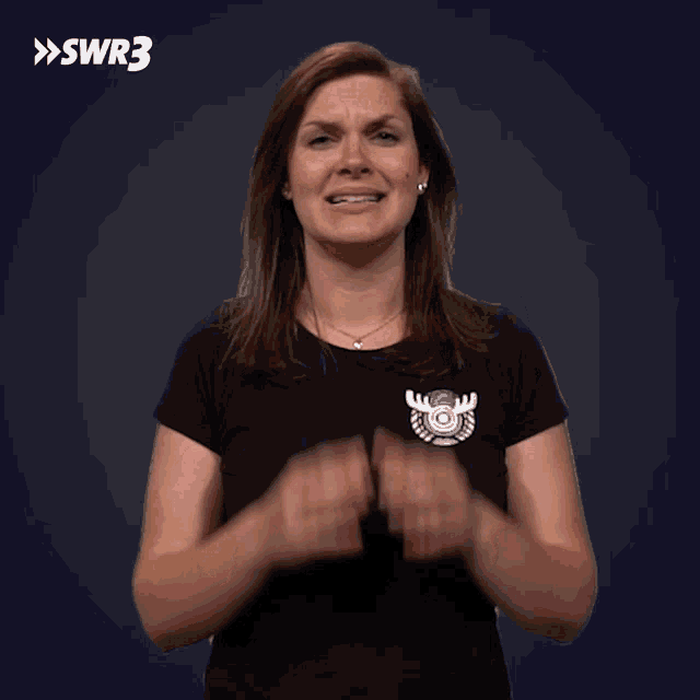 a woman in a black shirt is making a funny face with a swr3 logo in the corner