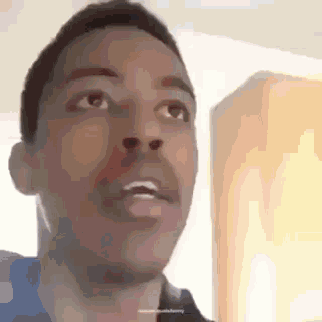 a close up of a man 's face with his mouth open and looking up .