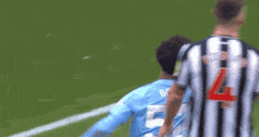 a soccer player with the number 4 on his back stands next to another player