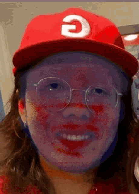 a woman wearing glasses and a red hat with the letter e on it