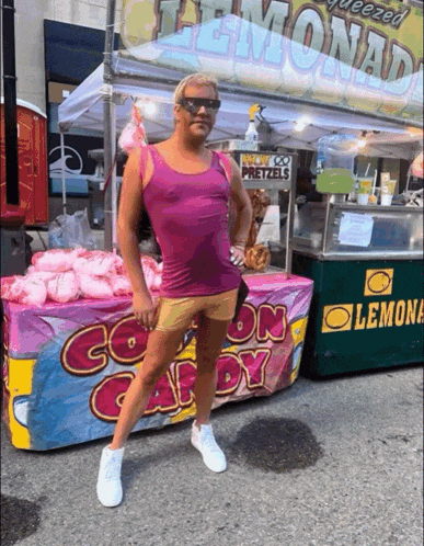 a man stands in front of a cotton candy stand