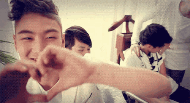 a man making a heart shape with his fingers