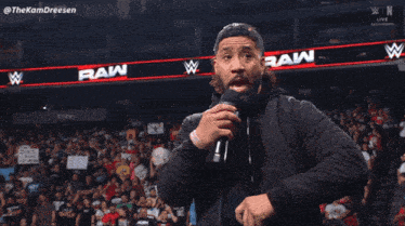 a man speaking into a microphone with the words " hell yeah i 'm crashing out " behind him