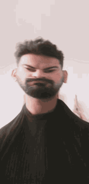 a blurry picture of a man with a beard making a funny face
