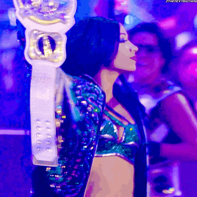 a woman in a sequined jacket is holding a trophy that says " the next thing " on it