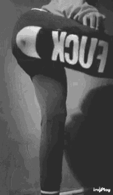 a black and white photo of a person wearing a shirt that says ' fuck ' on it .