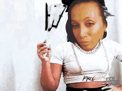 a woman in a white crop top is holding a white object in her hand