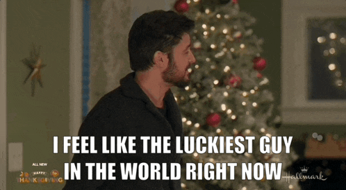 a man standing in front of a christmas tree with the words i feel like the luckiest guy in the world right now