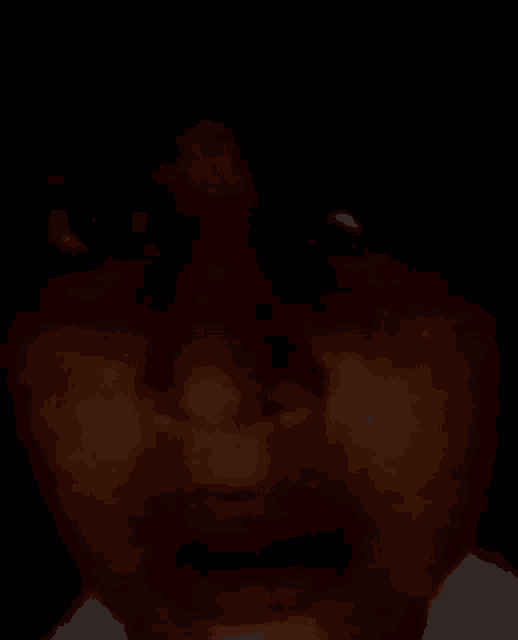 a close up of a person 's face in the dark with their eyes closed .