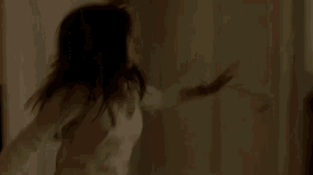 a woman is walking down a set of wooden stairs .