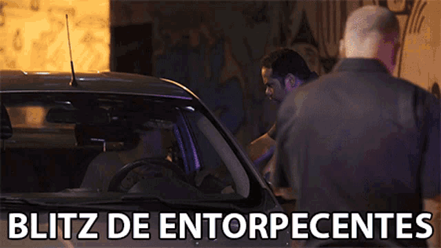 a man standing next to a car that says blitz de entorpecentes on the bottom