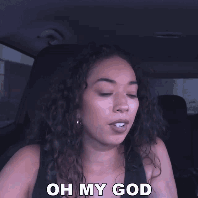 a woman sitting in a car with her eyes closed and says oh my god