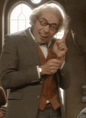 a man in a suit and glasses is pointing up .