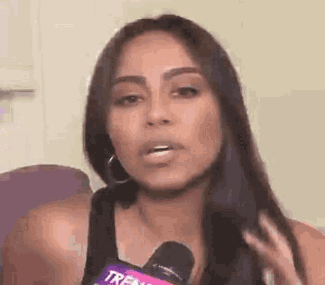 a woman is talking into a microphone and making a face .