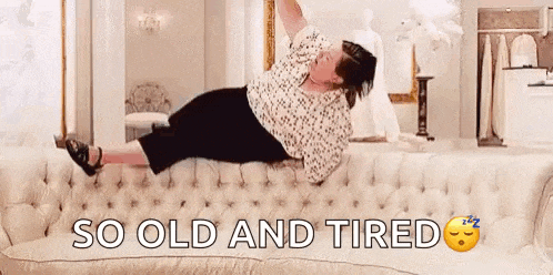 a woman is laying on her stomach on a couch and says `` so old and tired '' .