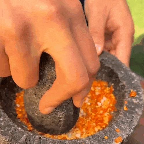 a person is using a mortar and pestle to crush a vegetable