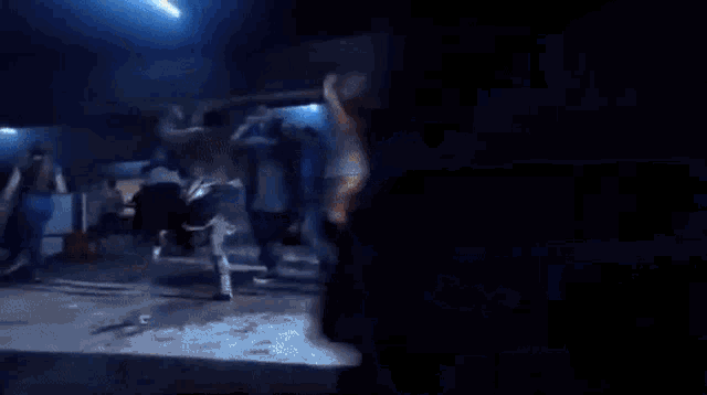 a group of people are dancing in a dark room
