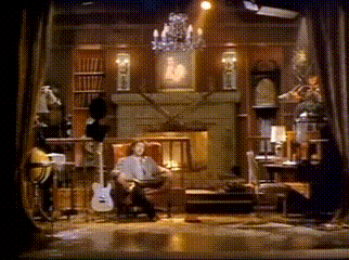 a man is sitting in a chair playing a guitar