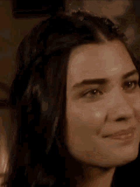 a close up of a woman 's face with her eyes closed and her hair in a ponytail .